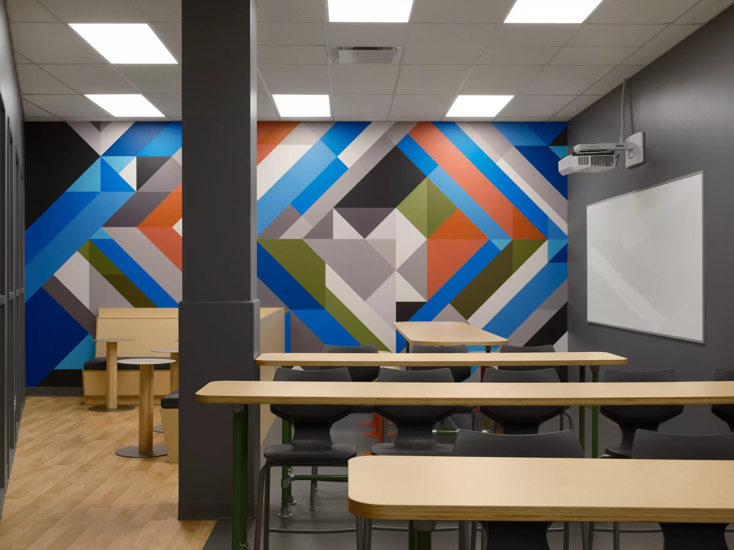 Détail d'une murale créée sur mesure pour l'aménagement. Des formes géométriques aux couleurs du mobilier.