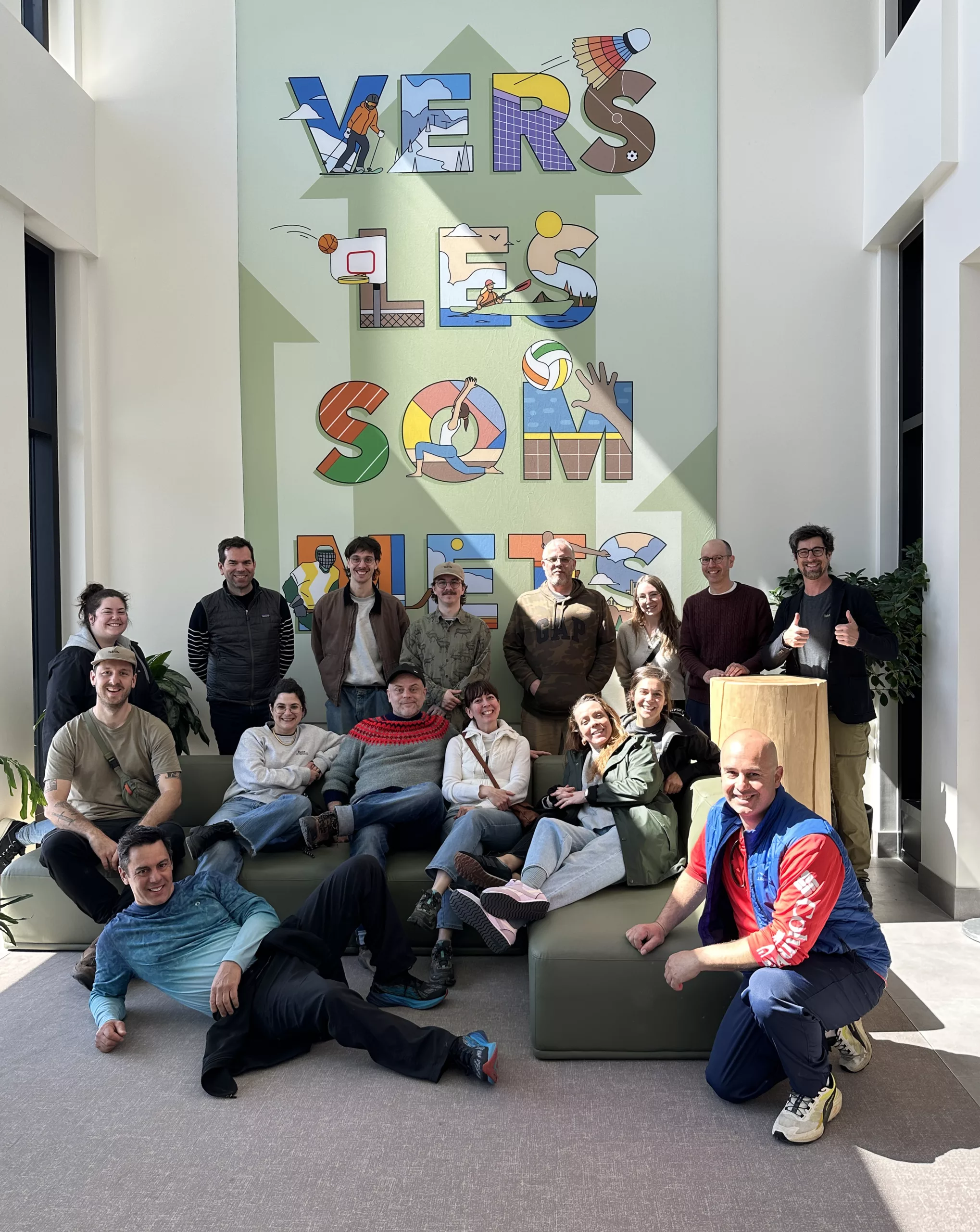 Les membres de l'équipe de Taktik design réunis devant une murale lors d'une visite chez un cient.
