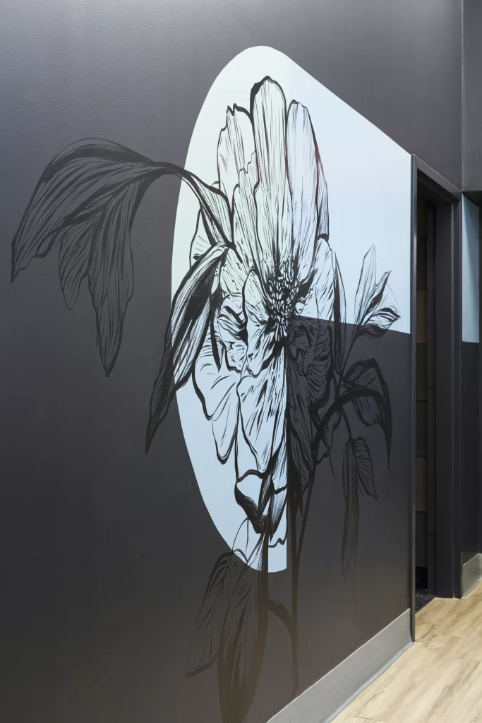 L'un des murs de l'une des classes flexibles du Pensionnat du Saint-Nom-de-Marie est décorée d'une représentation graphique d'une fleur de camélia apposée sur le mur.
