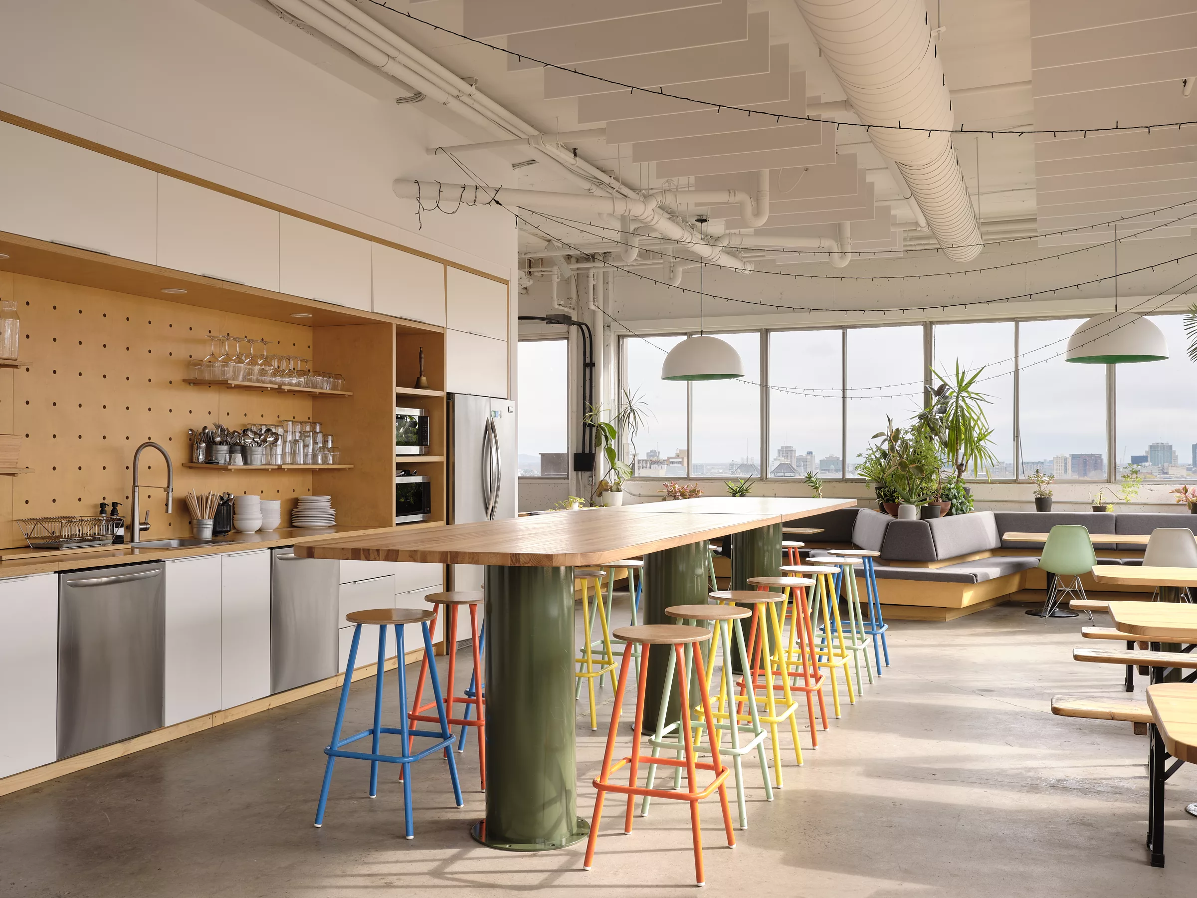 Bureaux de l'entreprise Transit. Vue de l'espace cuisine avec l'ilôt massif créé par Taktik. Un espace lumineux et spacieux avec vue sur la ville.