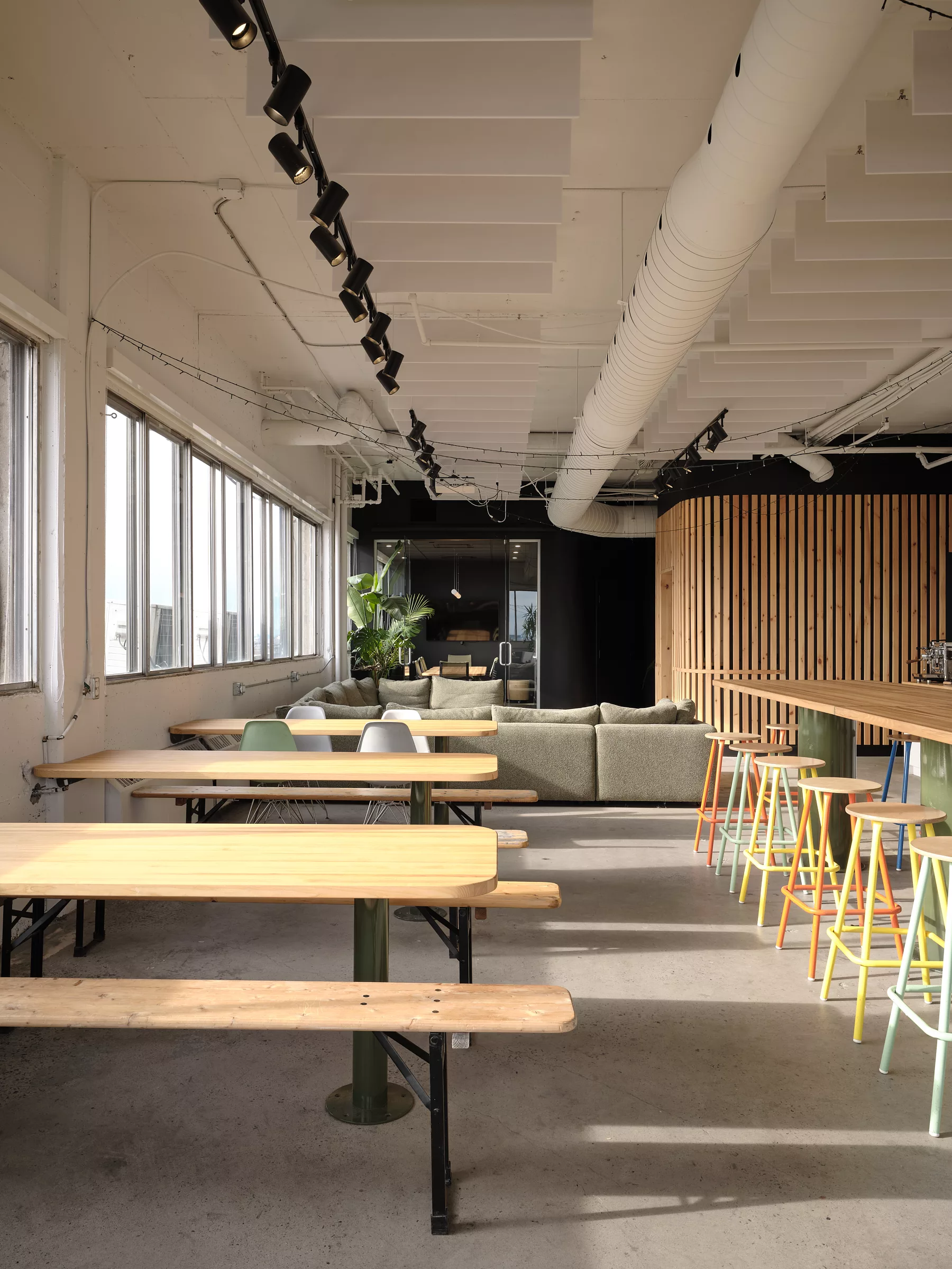 Bureaux de l'entreprise Transit. Vue vers la salle de réunion, avec les tables de lunch et de travail; en premier plan.