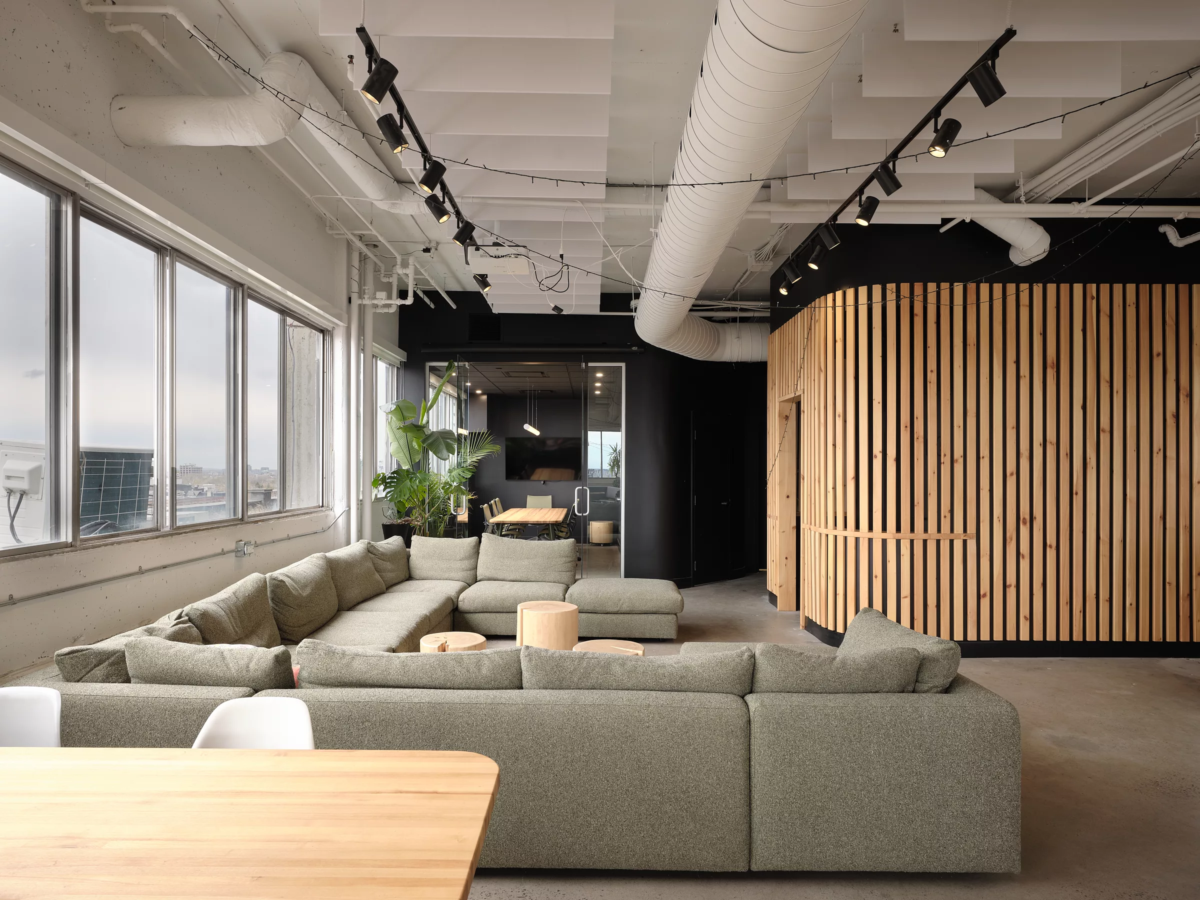 Bureaux de l'entreprise Transit. Vue vers la salle de réunion, avec l'espace détente en premier plan.