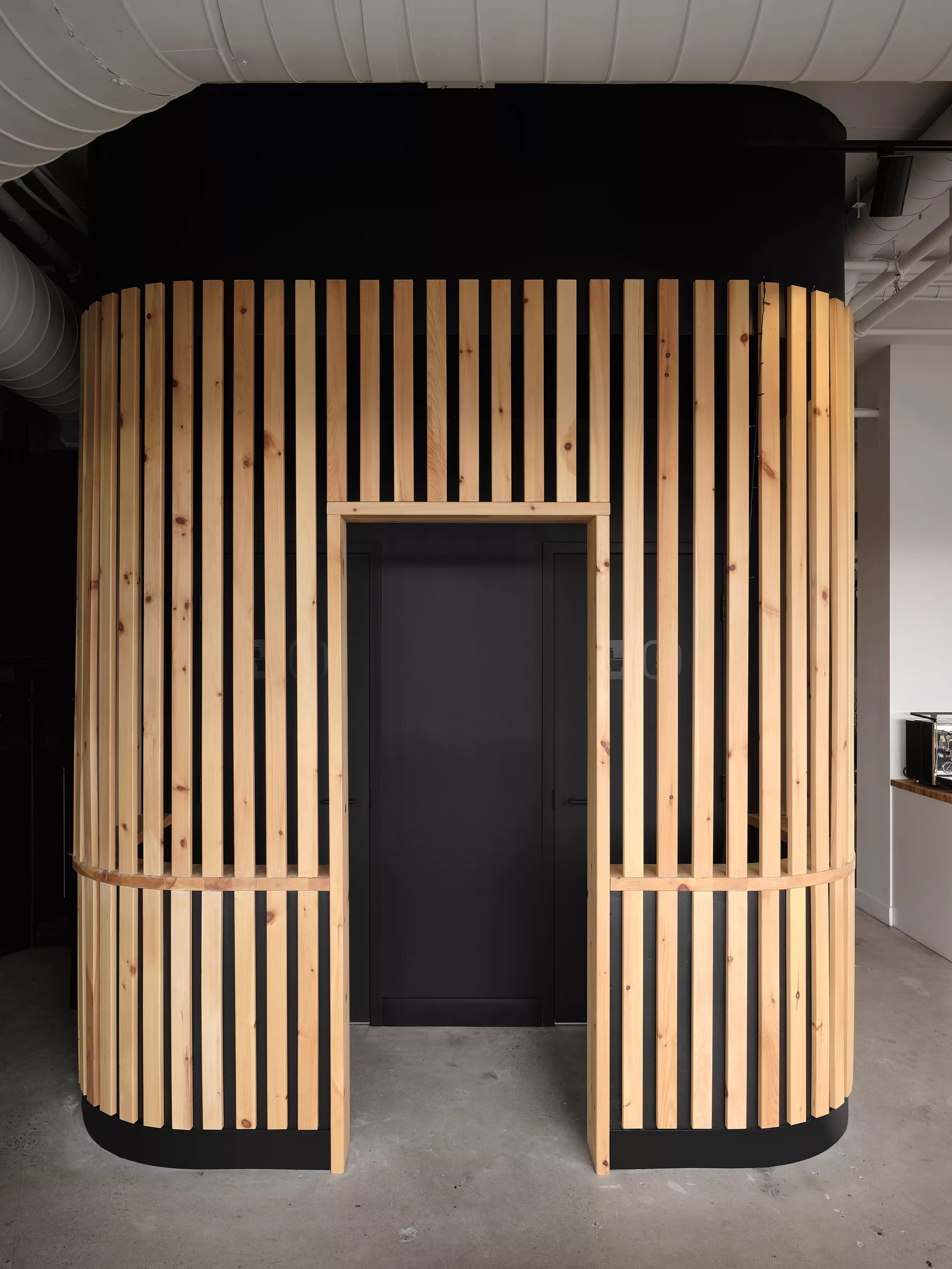 Vue de l'habillage du mur en lattes de bois dans les bureaux de Transit.