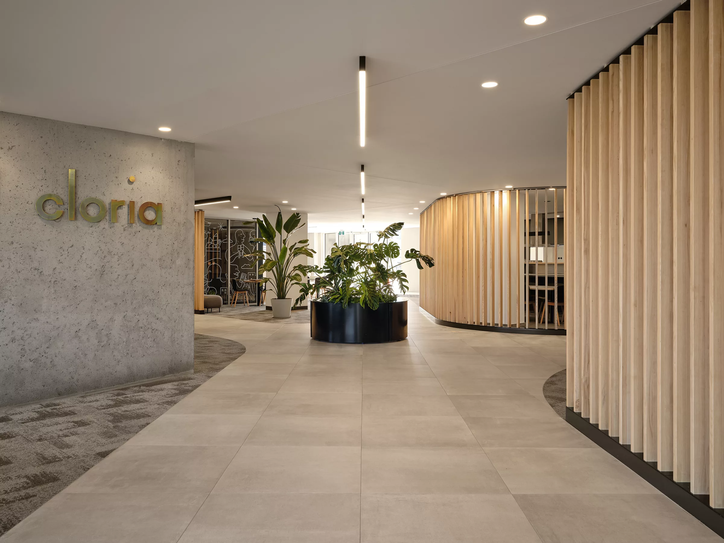 Vue du corridor de la résidence Cloria à Beloeil. On y voit le logo en acier zingué et des parois verticales en bois, en tourant le carrefour giratoire central.